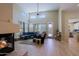 Open living room with stone fireplace, ceiling fan, high ceilings, and luxury wood floors at 32835 N 70Th St, Scottsdale, AZ 85266