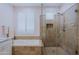 Bright bathroom with a shower and a tub and white plantation shutters on the window at 32835 N 70Th St, Scottsdale, AZ 85266