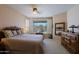 Bright main bedroom featuring neutral walls, ceiling fan, and a window view to the pool at 32835 N 70Th St, Scottsdale, AZ 85266