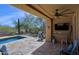 Inviting covered patio features a built-in grill, TV, and access to a refreshing pool at 32835 N 70Th St, Scottsdale, AZ 85266