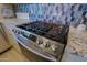 Close-up of stainless steel Samsung gas range with granite countertop at 32835 N 70Th St, Scottsdale, AZ 85266