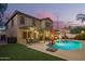 Spacious backyard with a large pool, covered patio, well-maintained lawn, and delightful outdoor lighting at 3473 E Wyatt Way, Gilbert, AZ 85297