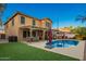 A vibrant backyard featuring a pool, manicured lawn, outdoor seating, and a charming pergola at 3473 E Wyatt Way, Gilbert, AZ 85297