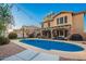 Expansive backyard oasis with a refreshing pool, lush lawn, covered patio, and string lights for evening ambiance at 3473 E Wyatt Way, Gilbert, AZ 85297