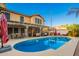 Gorgeous backyard featuring a sparkling pool, covered patio, outdoor bar, and manicured landscaping at 3473 E Wyatt Way, Gilbert, AZ 85297