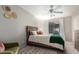 Comfortable bedroom with ceiling fan, a wooden bed frame, and neutral color palette at 3473 E Wyatt Way, Gilbert, AZ 85297
