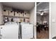 Laundry room with washer, dryer, shelving, and view into adjacent dining area at 3473 E Wyatt Way, Gilbert, AZ 85297