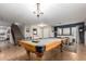 A billiard room features a wooden pool table beneath a chandelier, and a decorative bar with stools at 3473 E Wyatt Way, Gilbert, AZ 85297