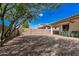 Backyard featuring covered patio, mature landscaping, and gravel groundcover at 3943 E Ficus Way, Gilbert, AZ 85298