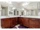 Bathroom with cherry-stained cabinets, dual sinks and large framed mirror at 3943 E Ficus Way, Gilbert, AZ 85298