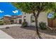 Beautiful home exterior with desert landscaping, mature tree, and a glimpse of the tile roof at 3943 E Ficus Way, Gilbert, AZ 85298