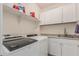 Well-lit laundry room featuring a washer, dryer, white cabinets, shelving, and granite countertops at 3943 E Ficus Way, Gilbert, AZ 85298
