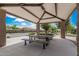 Shaded picnic area in community park boasts sturdy picnic tables, stone pillars, and open views, perfect for outdoor gatherings at 3943 E Ficus Way, Gilbert, AZ 85298