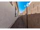 Exterior view of a stucco house with gravel landscaping between the building and block wall under a bright blue sky at 3943 E Ficus Way, Gilbert, AZ 85298