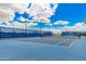 A pristine blue tennis court ready for a match, set against a clear blue sky perfect for outdoor play at 3943 E Ficus Way, Gilbert, AZ 85298