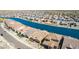 An aerial view of a neighborhood featuring waterfront properties, lush landscaping, and a serene canal at 40835 W Agave Rd, Maricopa, AZ 85138