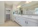 Bathroom featuring double sinks, white cabinets, and a large mirror at 40835 W Agave Rd, Maricopa, AZ 85138