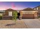 Single story home with a well-manicured yard and a two car garage at 40835 W Agave Rd, Maricopa, AZ 85138