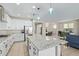 Spacious kitchen features white cabinetry, stainless steel appliances, and a large island with granite countertops at 40835 W Agave Rd, Maricopa, AZ 85138