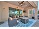 Relaxing covered patio with comfortable seating, a ceiling fan, a TV, and a fire table for outdoor enjoyment at 4306 W Summerside Rd, Laveen, AZ 85339