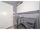 Well-equipped laundry room featuring a modern washer and dryer set, plus ample storage in the overhead white cabinets at 4306 W Summerside Rd, Laveen, AZ 85339