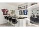 Stylish home bar features sports memorabilia, modern black bar stools, and ample storage at 4812 S Windstream Pl, Chandler, AZ 85249