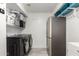 Organized laundry room with modern washer, dryer, storage shelves, and bright lighting at 4812 S Windstream Pl, Chandler, AZ 85249