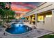 Stunning backyard pool featuring a spa, rock waterfall, and covered patio with outdoor kitchen at 4812 S Windstream Pl, Chandler, AZ 85249