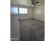 This bedroom features plush carpeting, a ceiling fan, and a bright window at 4924 W Catalina Dr, Phoenix, AZ 85031