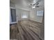 Large room featuring wood flooring, two windows with blinds, and a glass door at 4924 W Catalina Dr, Phoenix, AZ 85031