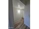 A well-lit hallway with wood floors and white walls, with an open doorway at the end at 4924 W Catalina Dr, Phoenix, AZ 85031