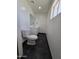 Bright bathroom with a white toilet and vanity, featuring sleek, dark marble-look floors at 5201 N 61St Dr, Glendale, AZ 85301