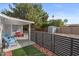 Cozy backyard patio features a modern horizontal fence, vibrant green turf, and shady trees at 639 N 57Th Pl, Mesa, AZ 85205