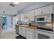 Well-lit kitchen with white cabinets, tile floors, and a stainless steel dishwasher at 639 N 57Th Pl, Mesa, AZ 85205