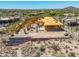 Aerial view of desert home under construction with wood framing, and retaining wall at 7646 E Hidden Canyon St, Mesa, AZ 85207