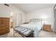 Bright bedroom featuring a comfortable bed, stylish bench, and ensuite bathroom at 8140 N 107Th Ave # 120, Peoria, AZ 85345