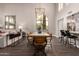Elegant dining room with a modern chandelier, large windows, and a view into the living room and kitchen at 8424 E San Bernardo Dr, Scottsdale, AZ 85258
