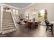 Beautiful open-concept space featuring a dining area that connects to the living room with high ceilings and a staircase at 8424 E San Bernardo Dr, Scottsdale, AZ 85258