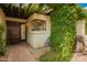 Charming front entrance with a wooden door, brick pathway, and lush, vine-covered pergola at 8424 E San Bernardo Dr, Scottsdale, AZ 85258