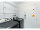 Well-organized laundry room features a modern washer and dryer set and plenty of shelving for storage at 8621 E Vista Dr, Scottsdale, AZ 85250