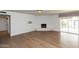 Bright living room with hardwood floors, a white brick fireplace, and a sliding door to the backyard pool at 8621 E Vista Dr, Scottsdale, AZ 85250