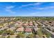 Expansive aerial view highlighting a vibrant community with many houses, greenery, and mountain views at 903 W Raven Dr, Chandler, AZ 85286