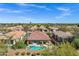 Aerial view of house with vibrant pool, covered patio, desert landscaping, and mountain views at 903 W Raven Dr, Chandler, AZ 85286