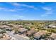 An expansive aerial view captures a community with lush greenery and mountain views under a clear blue sky at 903 W Raven Dr, Chandler, AZ 85286