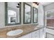Bathroom features a double vanity with decorative mirrors, tile countertops, and stylish lighting at 903 W Raven Dr, Chandler, AZ 85286