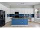 Well-equipped kitchen boasts white cabinets, a navy backsplash, and a center island with sink at 903 W Raven Dr, Chandler, AZ 85286