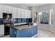 Bright kitchen with white cabinets, granite countertops, navy tile backsplash, and island at 903 W Raven Dr, Chandler, AZ 85286