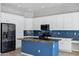 Charming kitchen featuring white cabinets, navy tile backsplash, island, and stainless steel appliances at 903 W Raven Dr, Chandler, AZ 85286