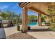 Outdoor living space with barbecue, covered patio, and desert landscaping overlooking a sparkling pool at 903 W Raven Dr, Chandler, AZ 85286