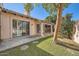 Exterior backyard with patio, green lawn, lush trees and stone walkway pavers at 10062 E Cinnabar Ave, Scottsdale, AZ 85258